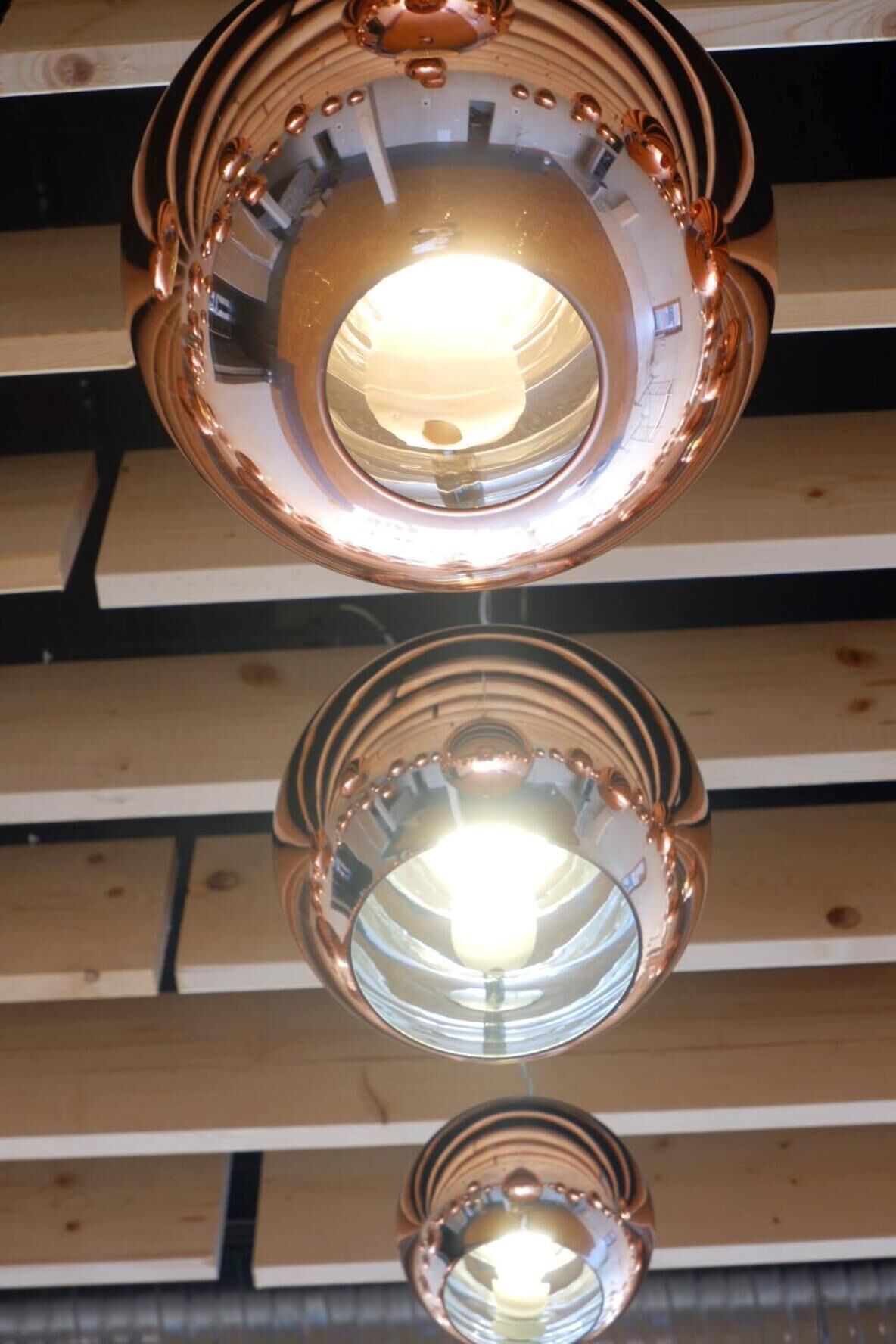 Un soffitto con due lampade circolari color rame.