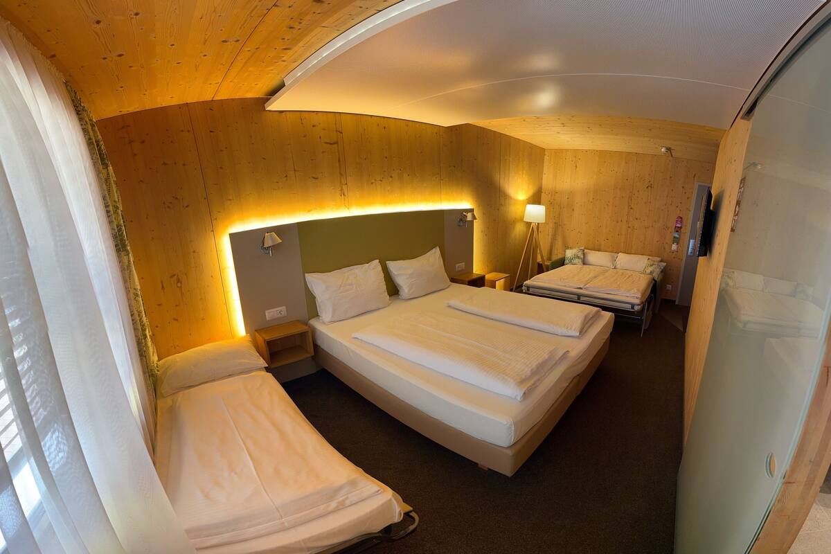 Ein Hotelzimmer mit zwei Betten, einem Schreibtisch und einer Lampe.