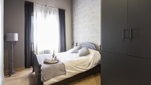 Une chambre à coucher avec un lit, une table de chevet, une lampe et une armoire.