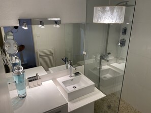 Chuveiro, secador de cabelo, toalhas de banho, papel higiênico