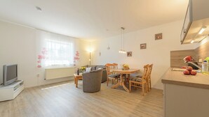 A modern apartment with a living room, dining area, and kitchen. - Apartment in Prerow up to 2 p. + child up to 6 y., quiet, close to the beach, parking lot, WLAN (Prerow)