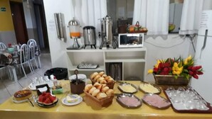 Buffet ple d'una varietat d'aliments, com pa, pastissos i embotits.