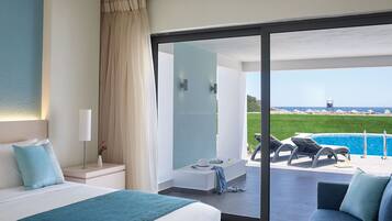 Een hotelkamer met een bed, een bank, een balkon met zwembad en uitzicht op zee.