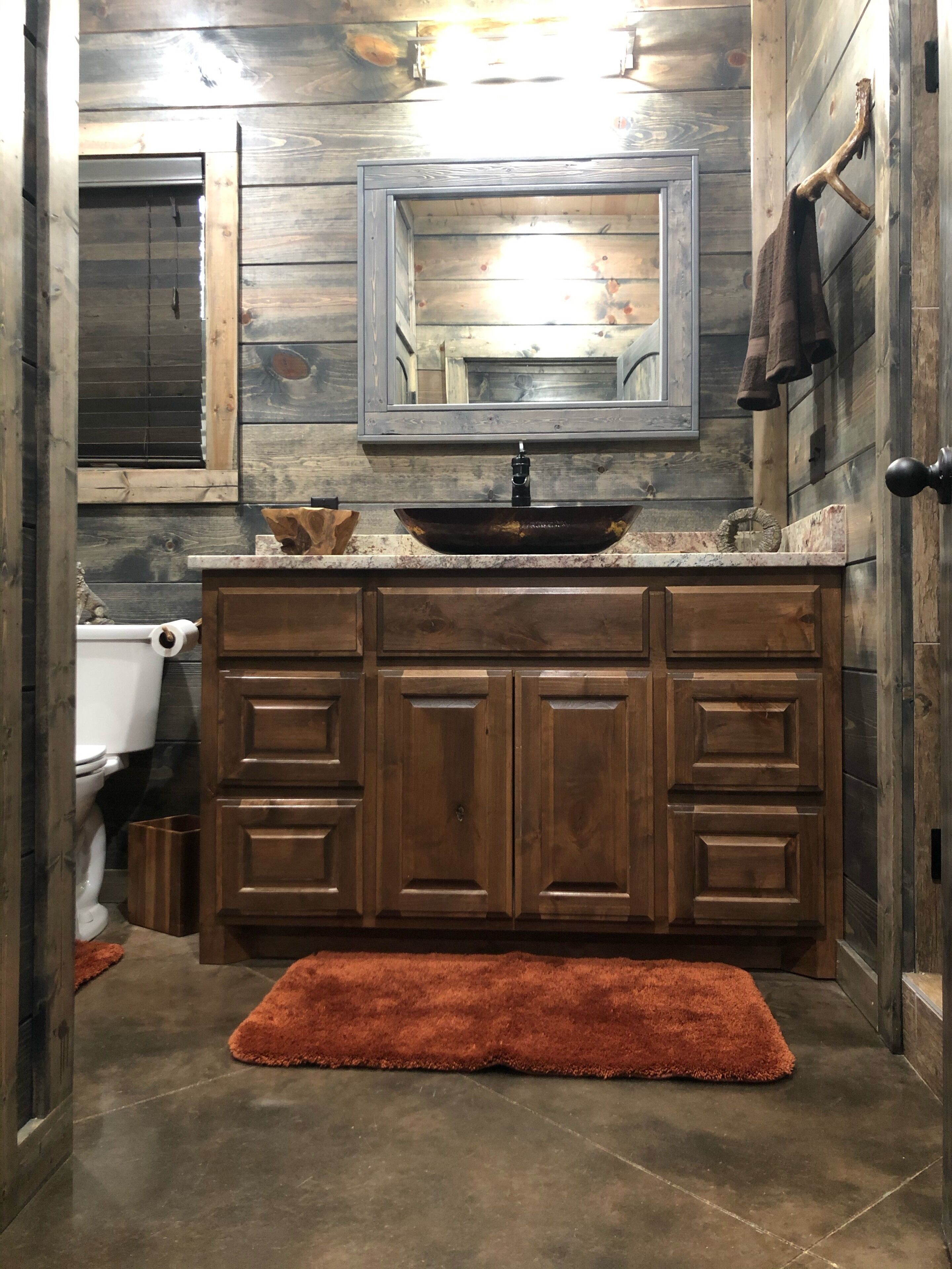 Une salle de bain rustique avec un meuble-lavabo en bois, un vasque et un grand miroir.