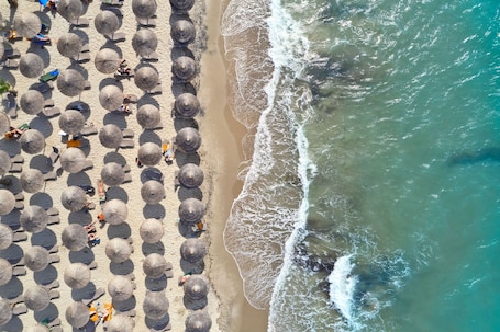 Una playa cerca, sillas reclinables de playa, sombrillas. Atlantica Marmari Palace