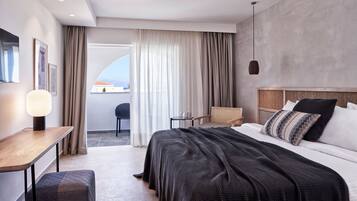 A modern hotel room with a large bed, a desk, a chair, and a view of the outdoors.