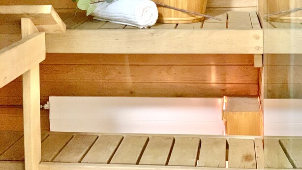 A wooden bench with a towel and a wooden bucket. - City Home Finland Centrum Studio - Sauna (Tampere)
