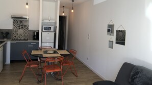 Un espace de vie compact comprenant une kitchenette, un coin repas et un coin salon.