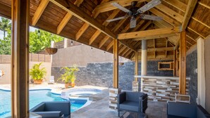 A covered outdoor area with a pool, seating, and a stone wall. - The Sun Seeker Villa Ja 9 Bedrooms . Fully staffed with private chef & butler  (Montego Bay)