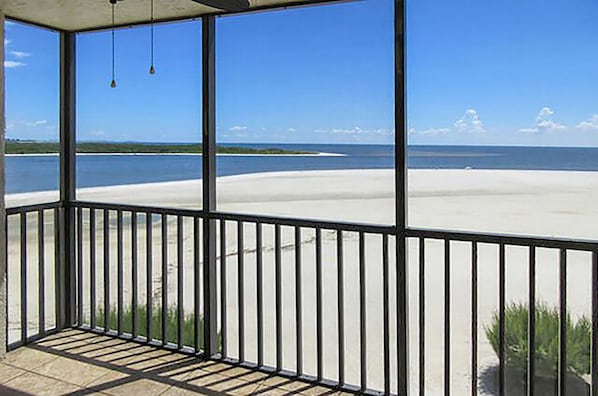 Un balcon avec vue sur une plage et l’océan.