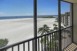 Un balcon avec vue sur une plage et l’océan.