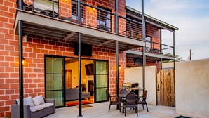 A two-story house with a swimming pool, outdoor furniture, and a balcony.