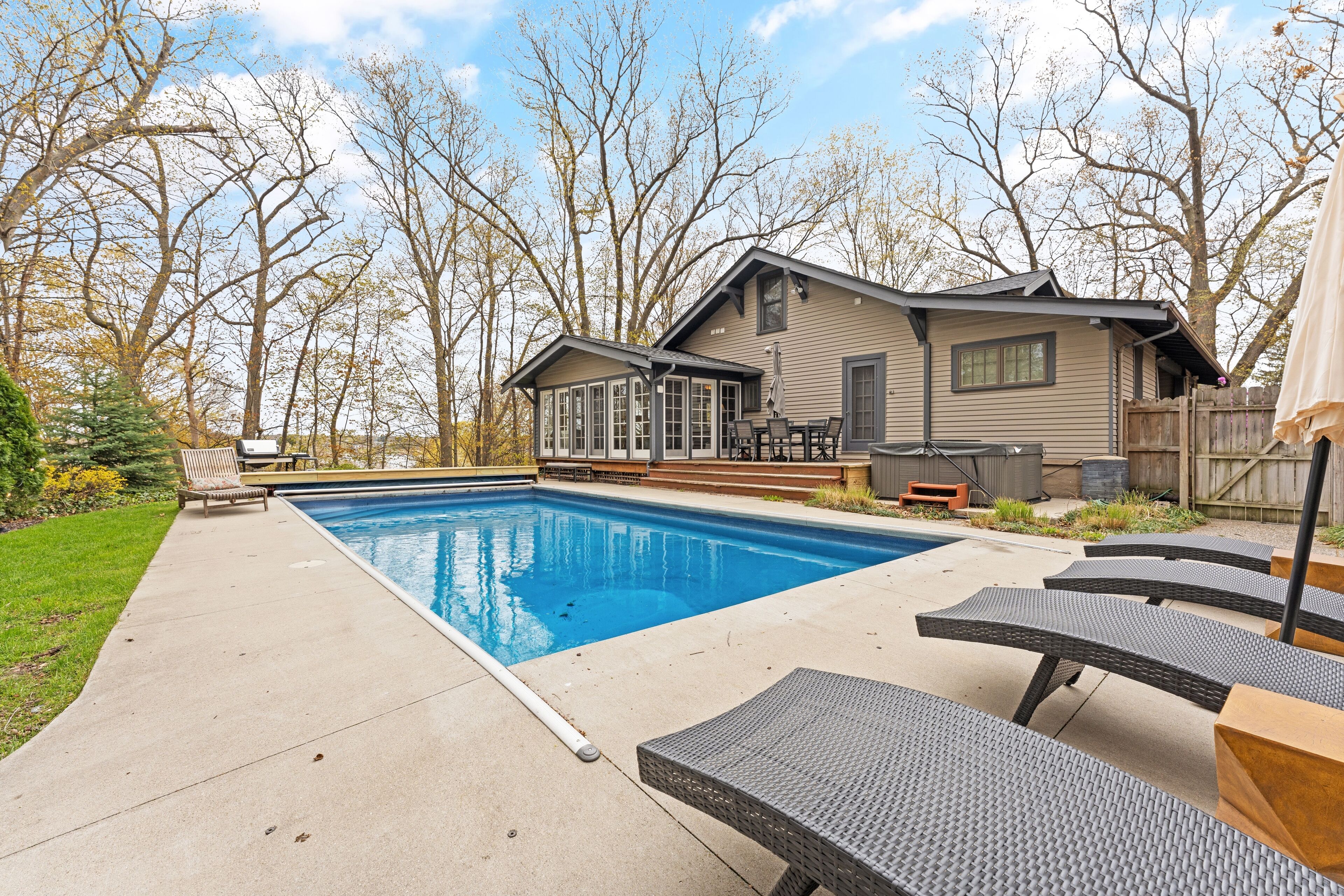 Un jardin avec une piscine, un patio couvert et du mobilier d’extérieur.