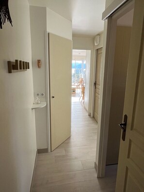 A hallway with a door leading to a balcony with a view of the city. - Sea views and beautiful pool (Cannes)