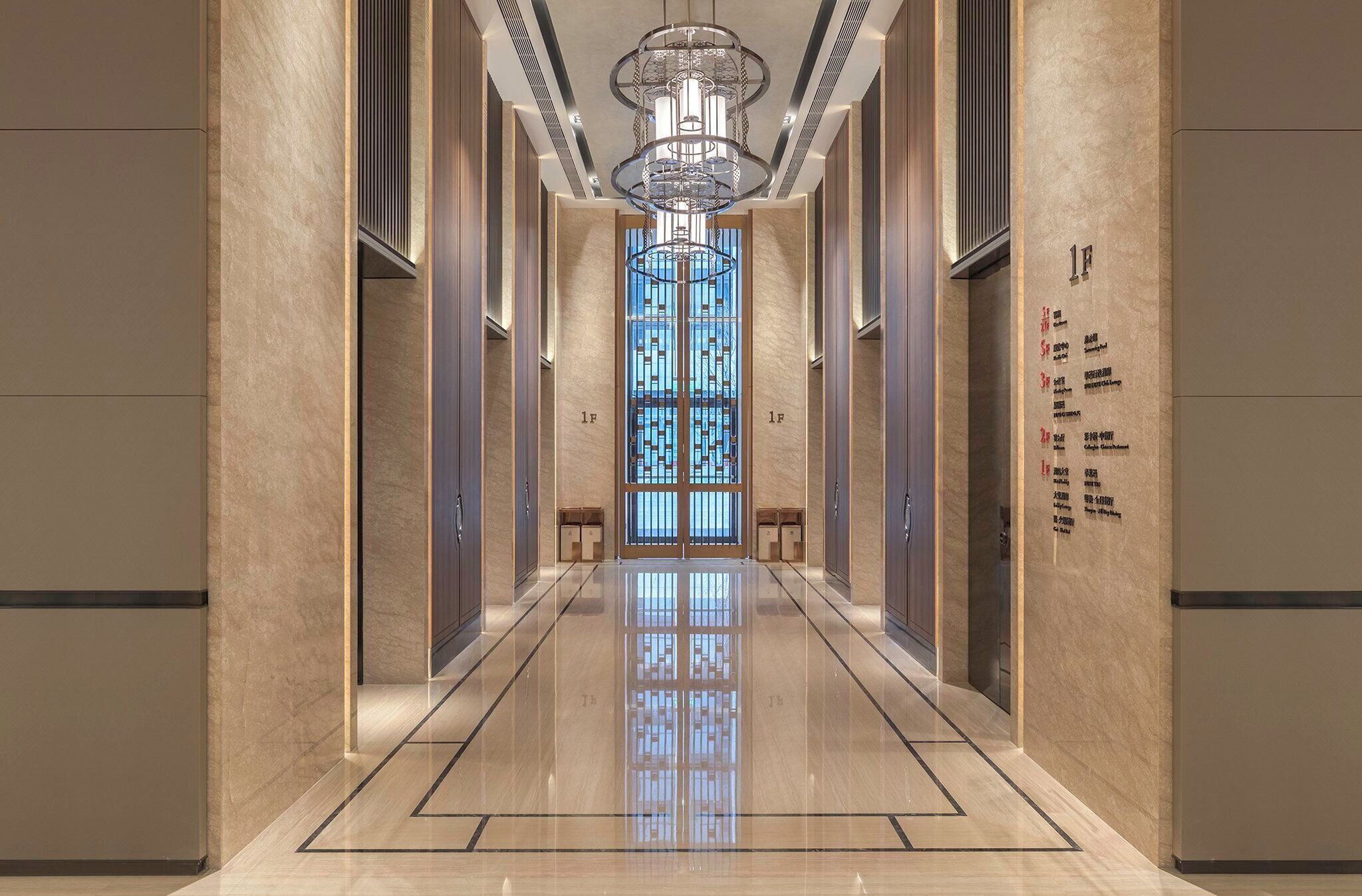 A hallway with a reflective floor, a central chandelier, and doors marked with room numbers.