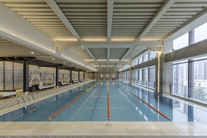 Una piscina techada, sillones reclinables de piscina