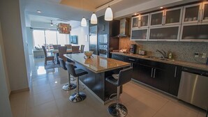 A modern kitchen with a central island, stainless steel appliances, and pendant lighting. - Mazatlán Solaria Oceanview Condo with Pool 704 (Mazatlan)