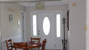 A dining area with a round table, wooden chairs, and a chandelier. - Beach House with Pool - Pet Friendly (North Myrtle Beach)