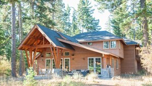 A log cabin with a sloped roof, large windows, and a covered porch. - Golf Course View w/ Suncadia Pool Access (Cle Elum)