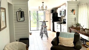 A kitchen with a dining area, a chandelier, and a view of the outdoors. - Home Base for New Smyrna Adventures (New Smyrna Beach)