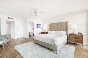 A bedroom with a bed, nightstands, a chair, and a ceiling fan. - Sandpiper Condominiums 801, Panoramic Gulf Views w/ direct access to Mustang Island/Port A beaches. (Port Aransas)