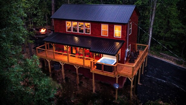 A two-story cabin with a deck, surrounded by forest. - Quiet Mountain Top Family Cabin- Private, Top Location, VIEWS! (Sevierville)