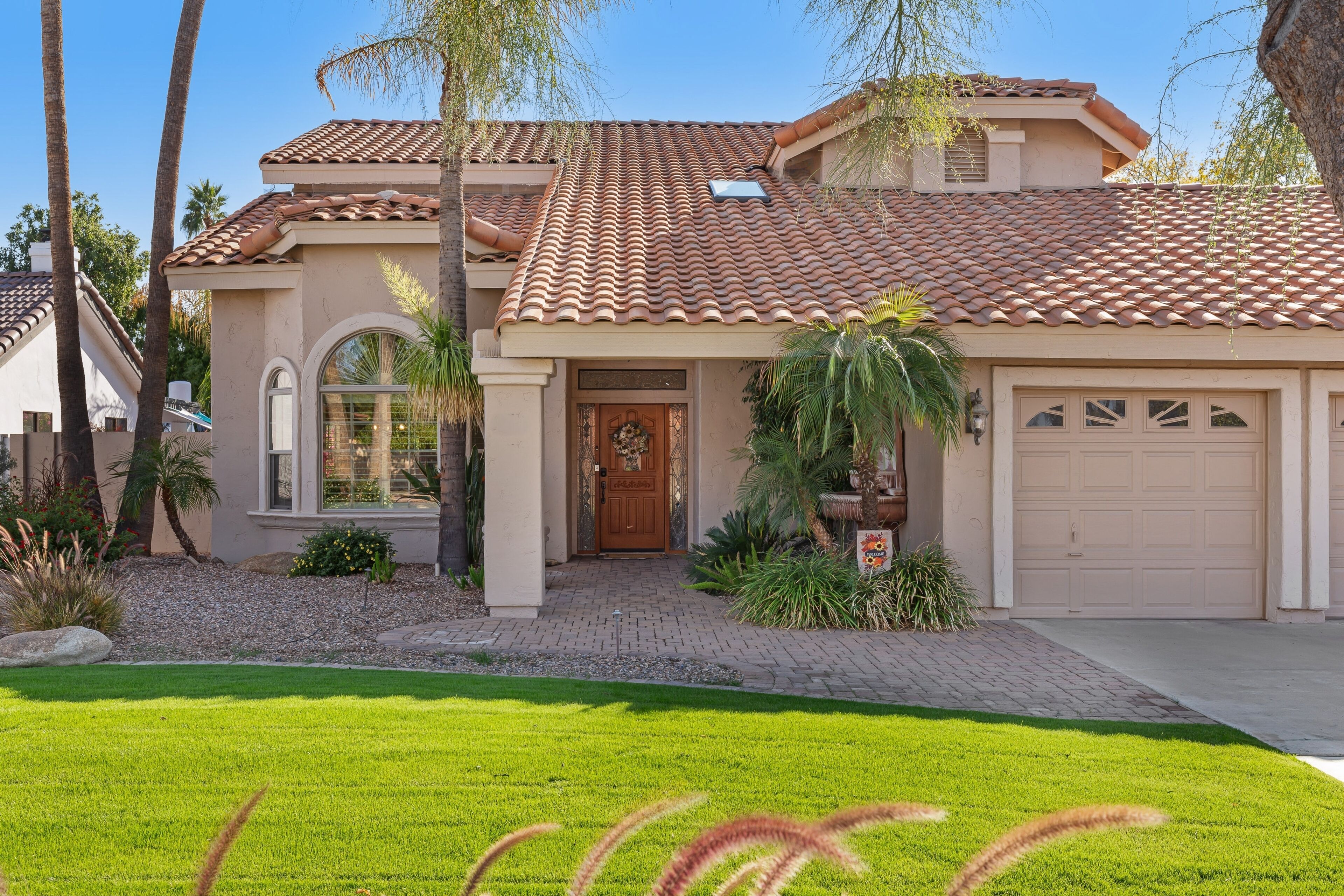 A single-story house with a tiled roof, a front door, and a garage.