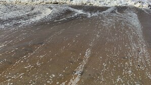 Uma praia com ondas quebrando na costa.