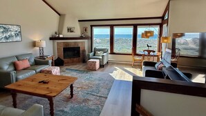Uma sala de estar com lareira, sofá, mesa de centro e televisão.