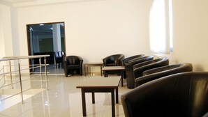 A modern interior with leather seating, a glass railing, and a view of a hallway. - Hotel Polaris (Scheia)