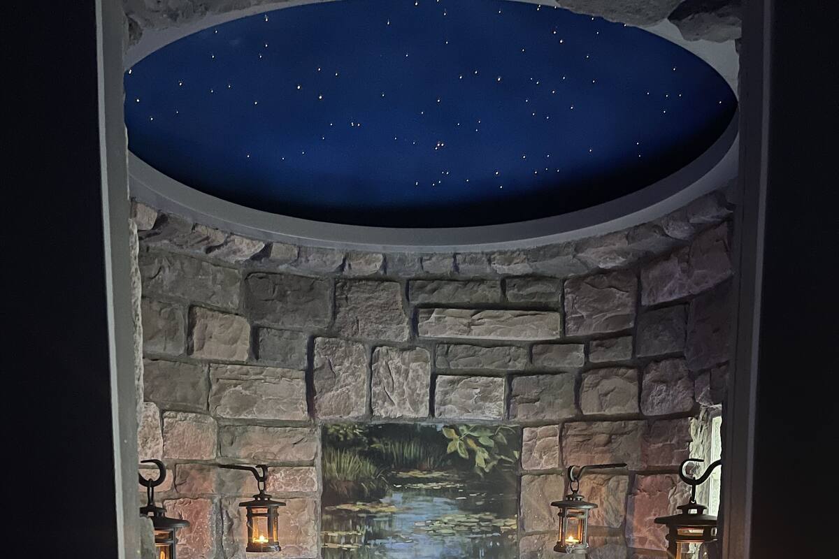 A spa area with a stone wall, a mural of a pond, and two lanterns.