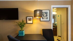 A dining area with a table, chairs, a potted plant, and a hanging lamp. - Mar Vista Suite of Private Entry,Patio & Spa Bath (LOS ANGELES)