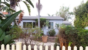 A house with a white picket fence, a small garden, and a large potted plant in front. - Mar Vista Suite of Private Entry,Patio & Spa Bath (LOS ANGELES)
