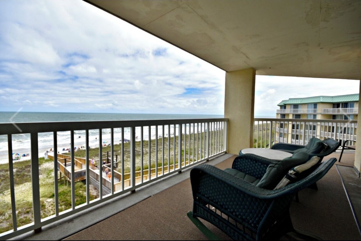 Varanda com mobiliário de vime com vista para a praia.