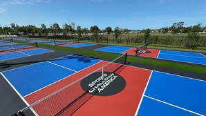 A sports court with multiple tennis courts, each marked with a net and labeled "SPORTS CHALLENGE AMERICA".