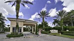 A hotel entrance with a covered walkway, palm trees, and a sign reading "Marbella."