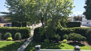 A well-maintained garden with a pathway leading to a white fence. - Close to Everything A (Kelowna)