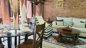 A dining area with a round glass table, chairs, and a buffet setup. There is a sofa with cushions and a patterned rug in the background. - Downtown New Orleans Penthouse Suite - 2 Minute Walk to French Quarter -4B (New Orleans)
