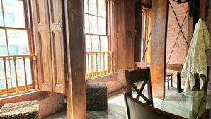 A wooden interior with large windows, a glass table, and wicker furniture. - Downtown New Orleans Penthouse Suite - 2 Minute Walk to French Quarter -4B (New Orleans)