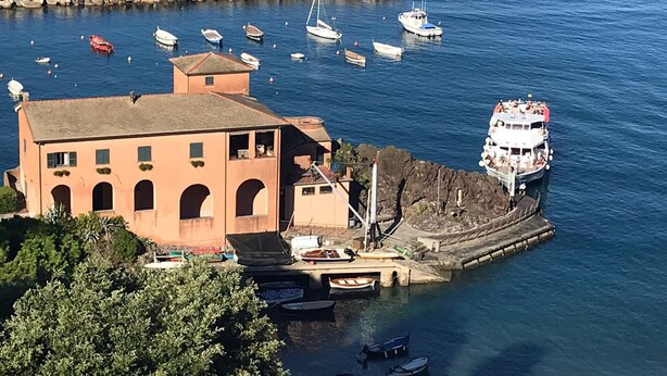 A coastal building with a dock, surrounded by calm water and several boats. - Sant'Antonino Apartments - Scirocco (levanto)