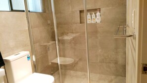 Een douche, handdoeken, toiletpapier