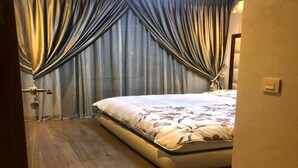 A bedroom with a bed, wooden flooring, and curtains. - Residence Hivernage Founty 4748 (Agadir)