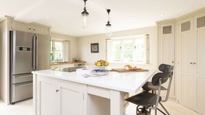 A spacious kitchen with a large island, stainless steel appliances, and a view of the outdoors. - Manor Farmhouse, Cruxton, Dorchester (Cruxton)