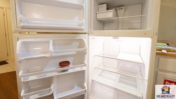 An open refrigerator with multiple shelves and compartments, including a freezer section at the top.