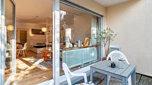 A modern living space with a dining area, a sofa, a table, and a radiator. - Cosy Studio Apartment in Quiet Area with Wi-Fi, Terrace & Garden (Pforzheim)