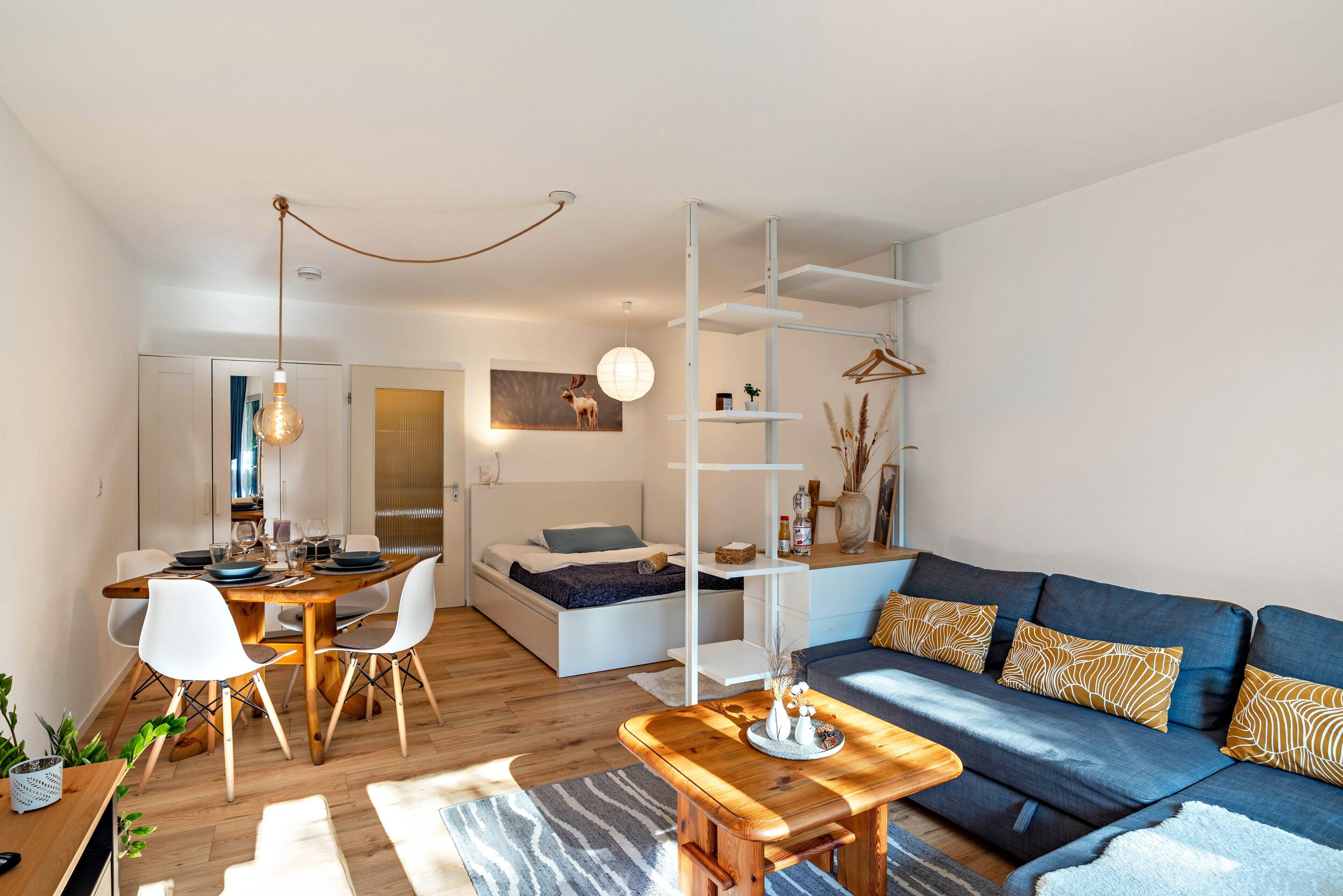 Un salon moderne avec un canapé, une table basse et un coin repas avec des chaises.