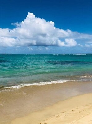 Een strand met helder turquoise water en een zandstrand.
