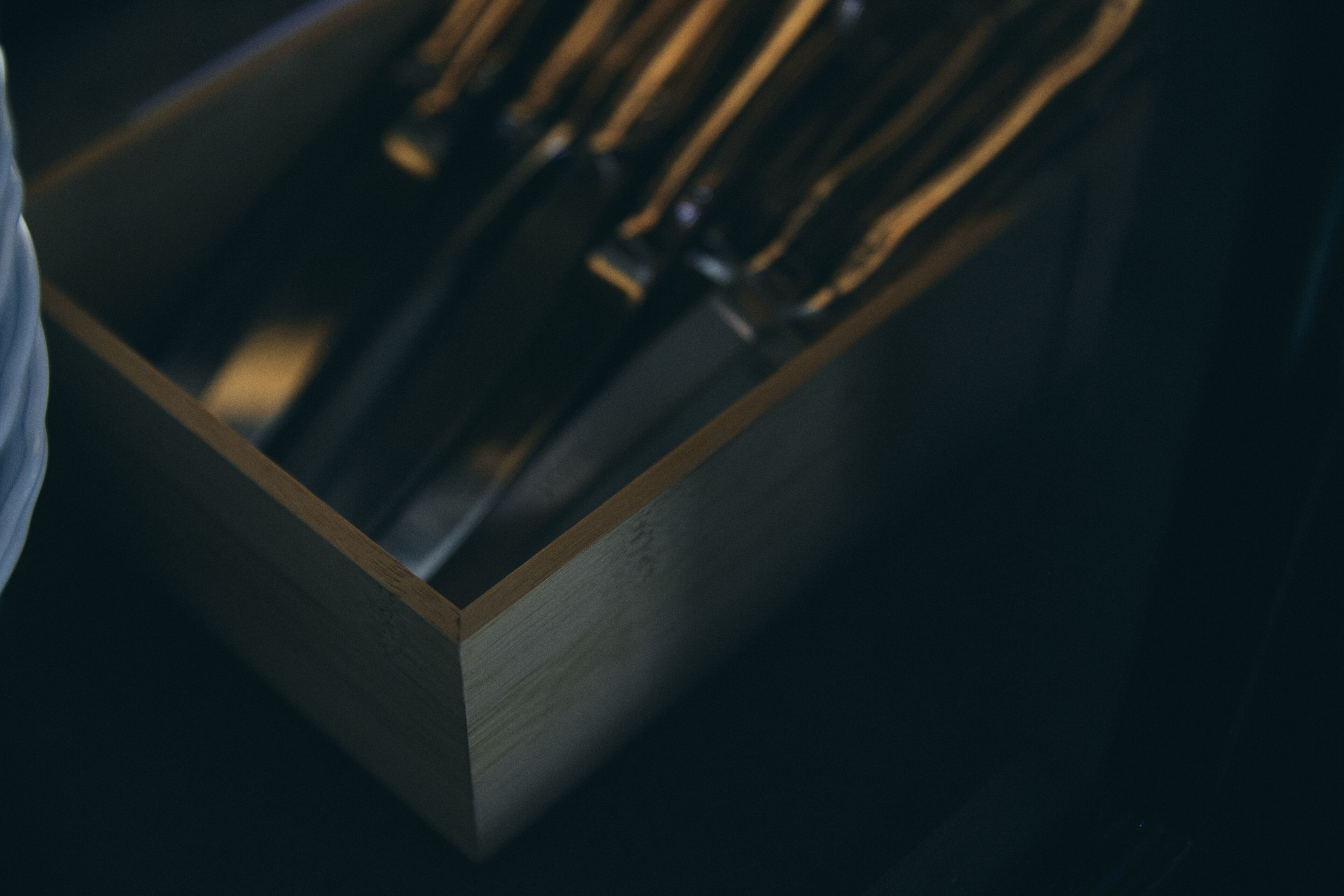 Een detailopname van een houten doos met daarin verschillende metalen voorwerpen.