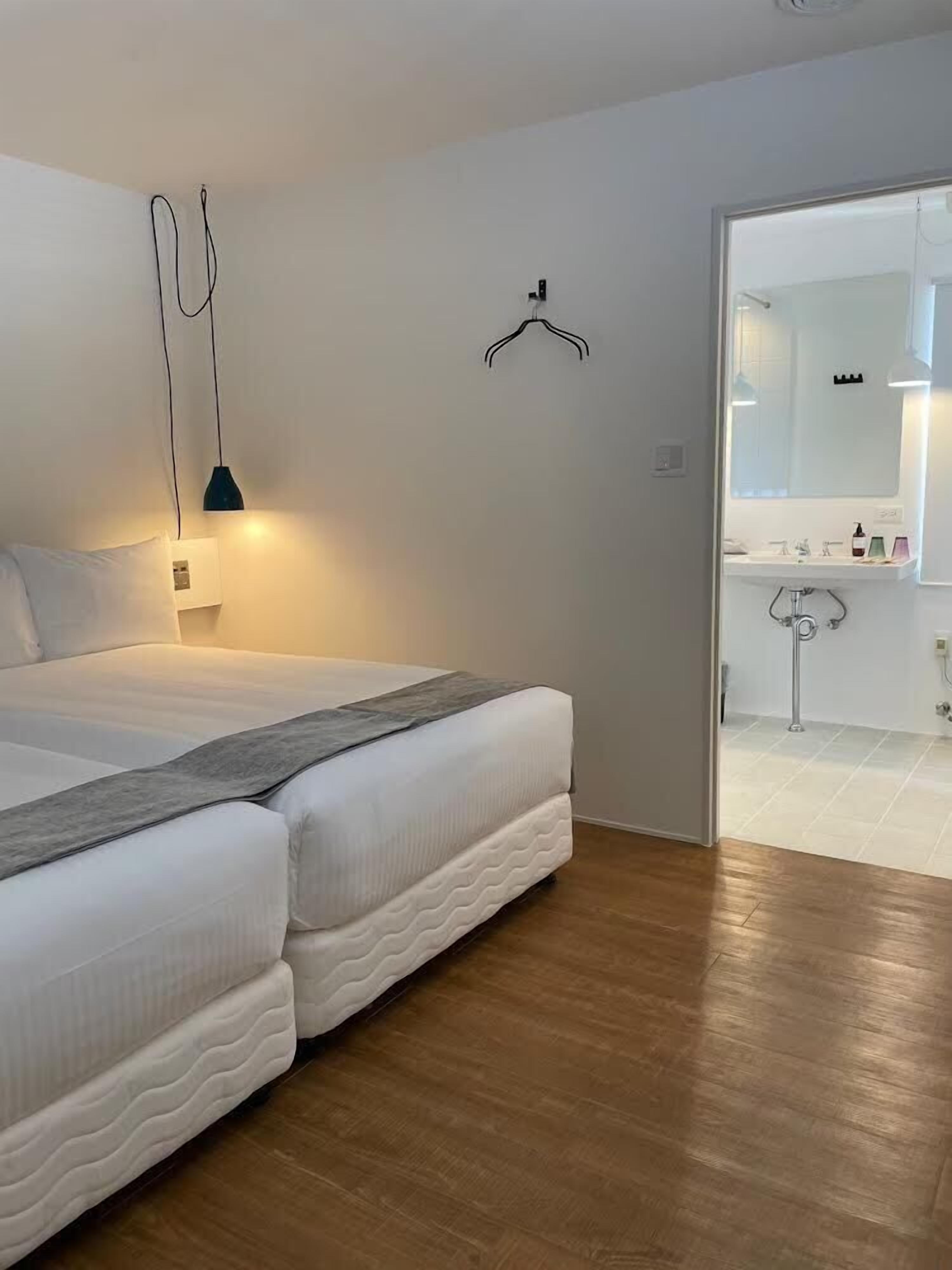 Une chambre à coucher avec un lit, une lampe de chevet et une vue sur la salle de bain.