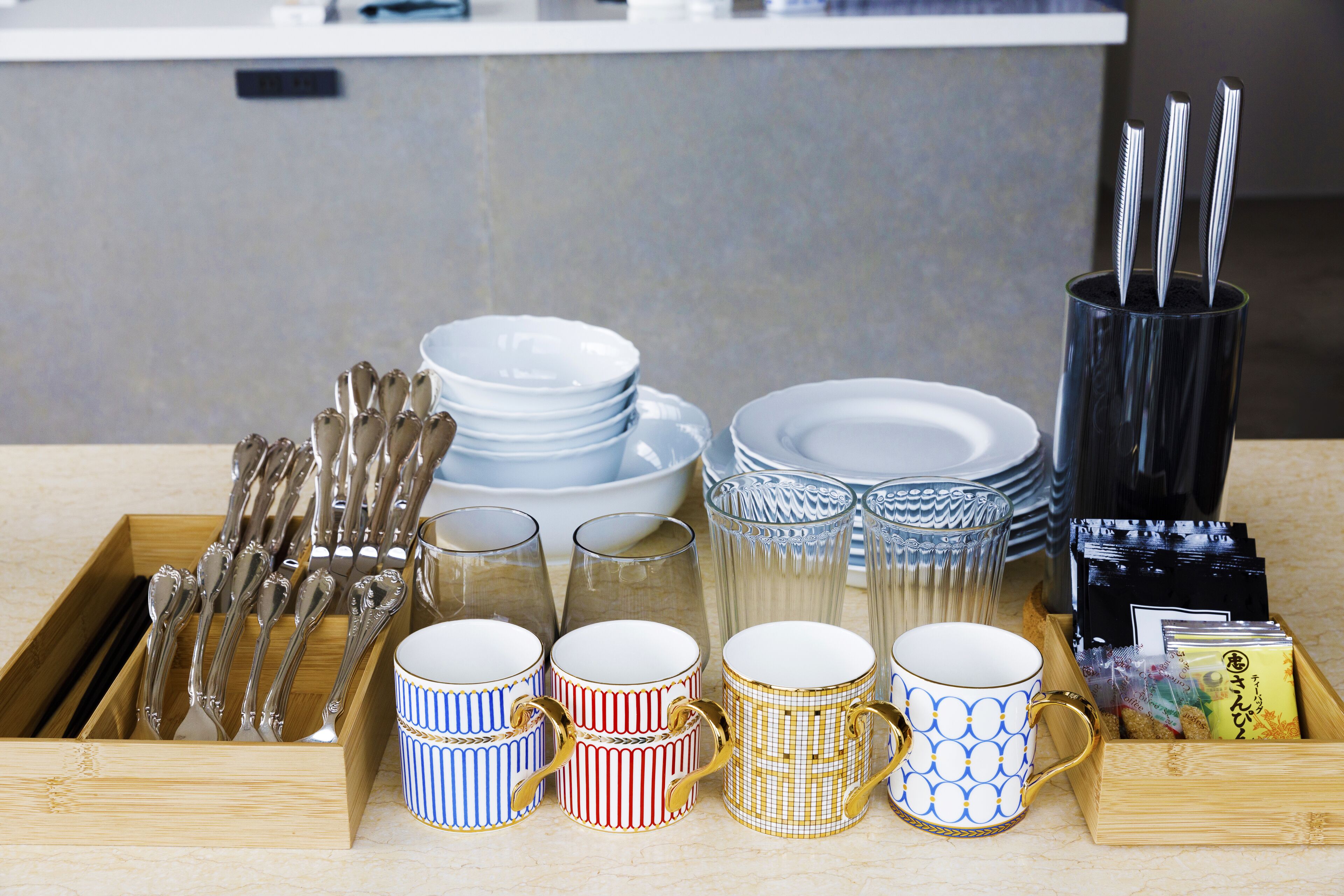 A tray with various dining utensils, plates, and cups.
